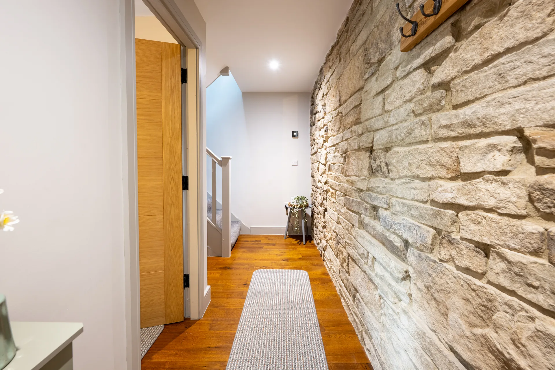 Hallway with wooden floor and exposed stone wall