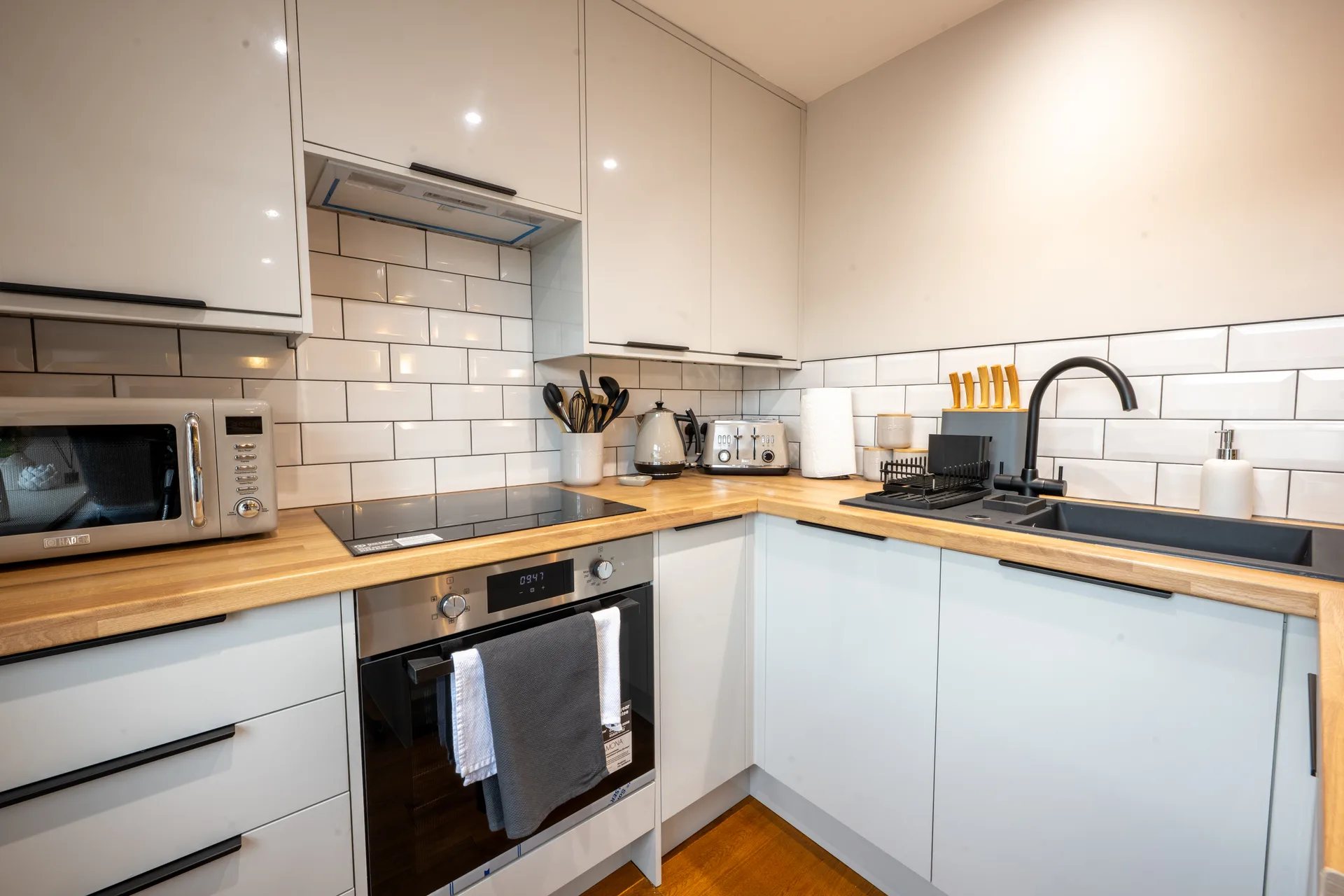 Kitchen with white cabinets, wooden countertops and a sink