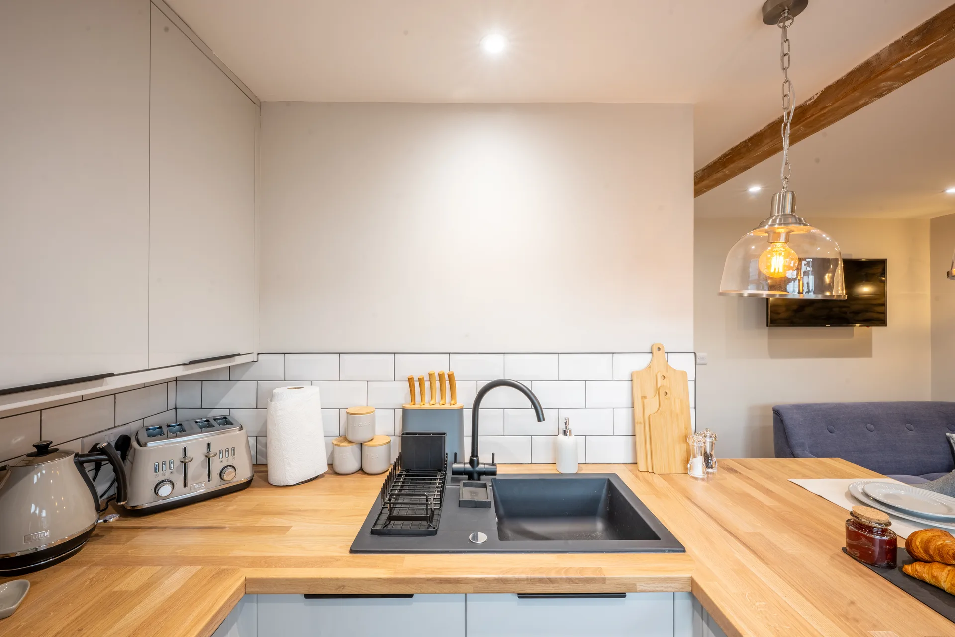 Kitchen counter with sink, microwave and white cabinets